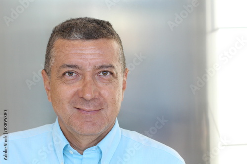 Portrait of mature Hispanic businessman smiling inside office building