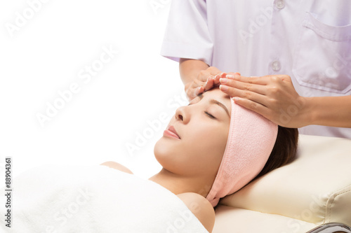 Beauty and Spa - massage of face for woman in spa salon, enjoying a facial massage, isolated on white with clipping path.
