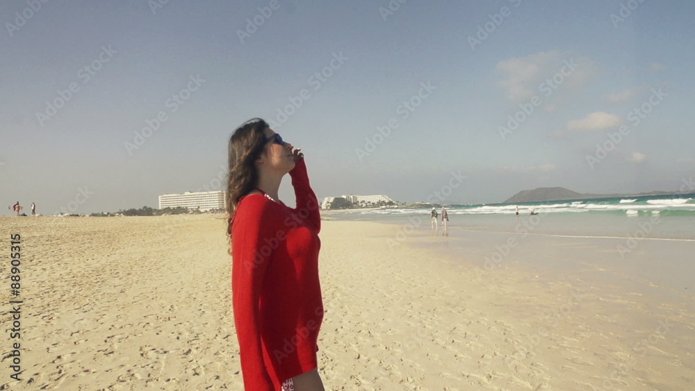 Young woman walking on beach and enjoying sunny day
