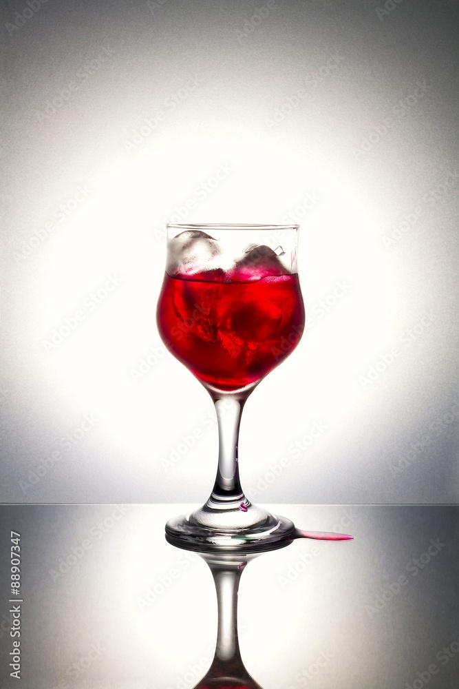 Red syrup on ice with gray background.Used color tool.