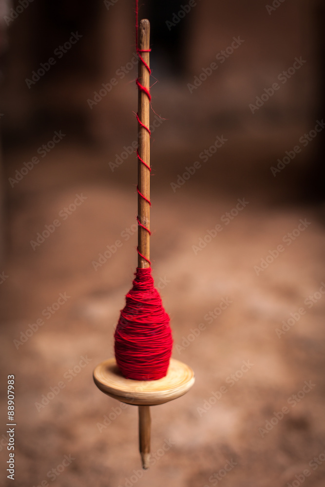 Stockfoto fuso per filare la lana in rotazione, avvolto con lana rossa |  Adobe Stock