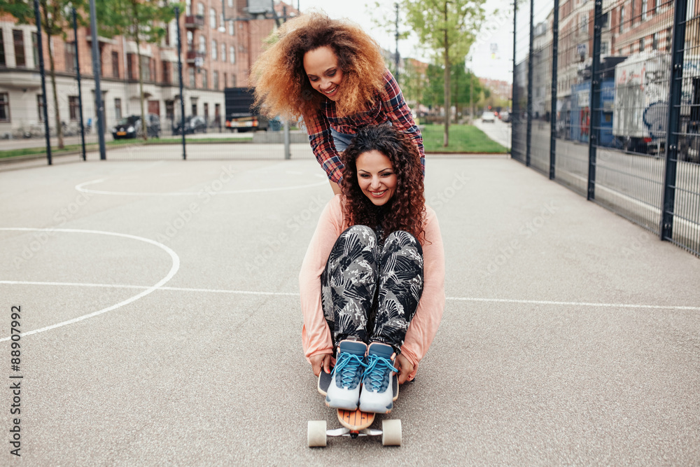 Young girls skating in basketball court