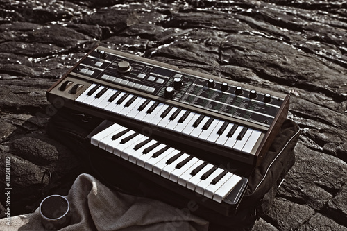 Music synthesizer lying on rocks close up