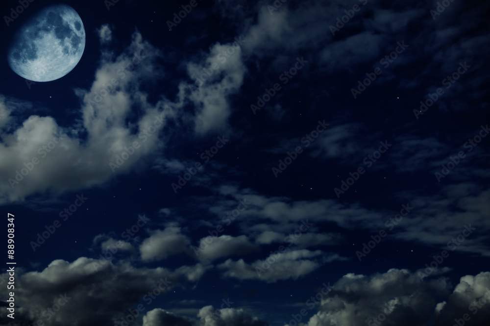 Night blue cloudy sky with stars and a moon
