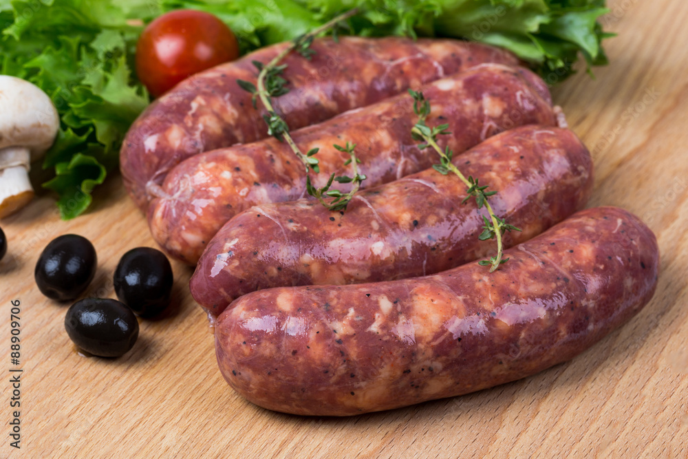 uncooked raw sausages on wooden board uncooked raw sausages on wooden board
