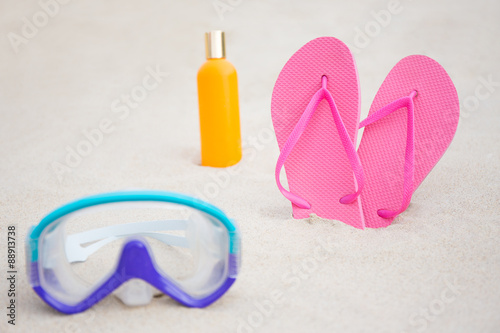 close up of diving mask, flip flops and suntan lotion bottle on