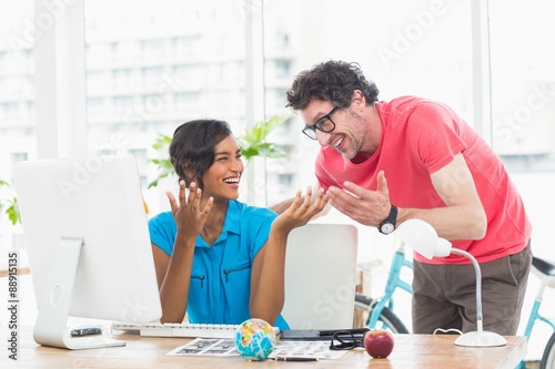 Portrait of cheerful colleagues using computer