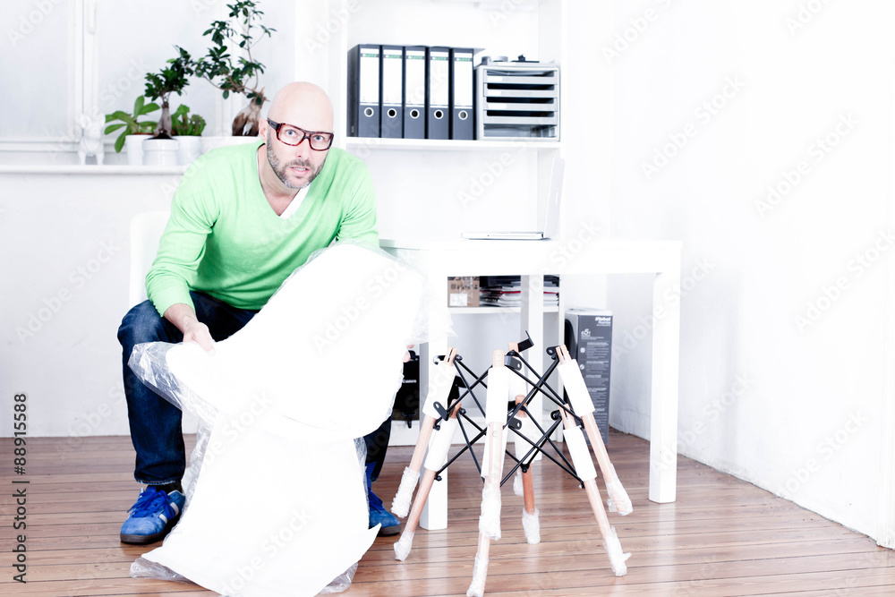 Mann baut Designer-Stuhl auf Mann baut Designer-Stuhl auf