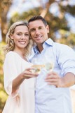 Portrait of smiling couple embracing and toasting with wineglass
