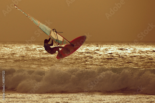 windsurfer jumping in a sunset sky #88917123