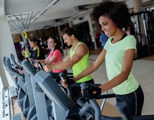 People exercising on a cardio training machines in a gym