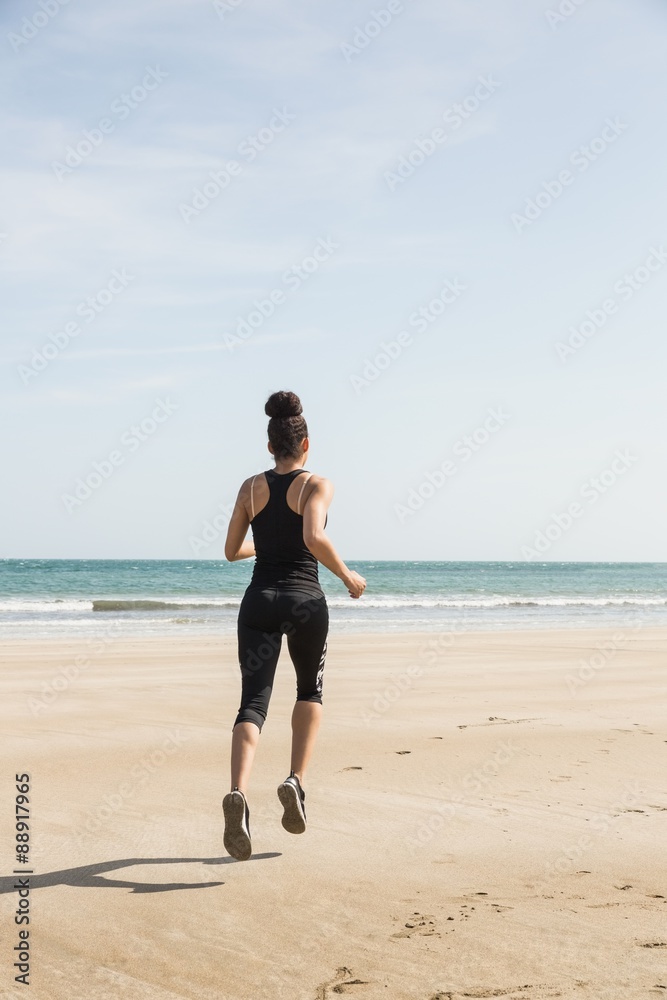 Fit woman jogging on the sand
