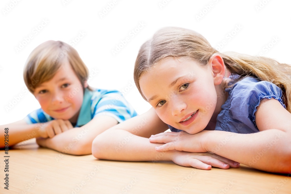 Composite image of cute pupils resting on their arms Composite image of cute pupils resting on their arms