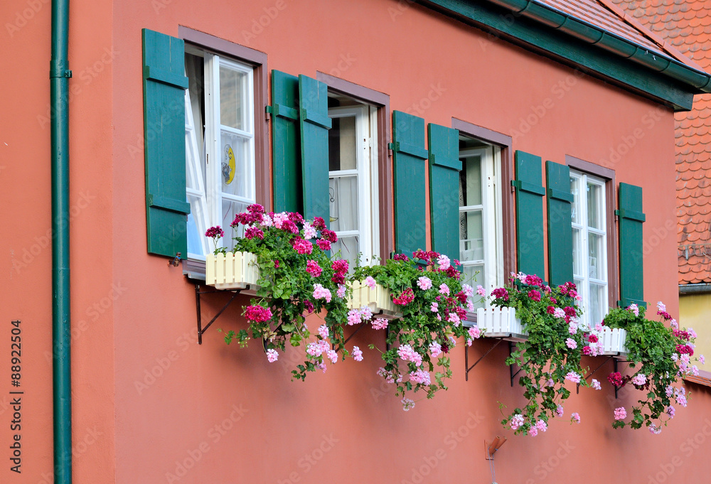 Dinkelsbühl - Vier Fenster mit Blumenschmuck in roter Wand