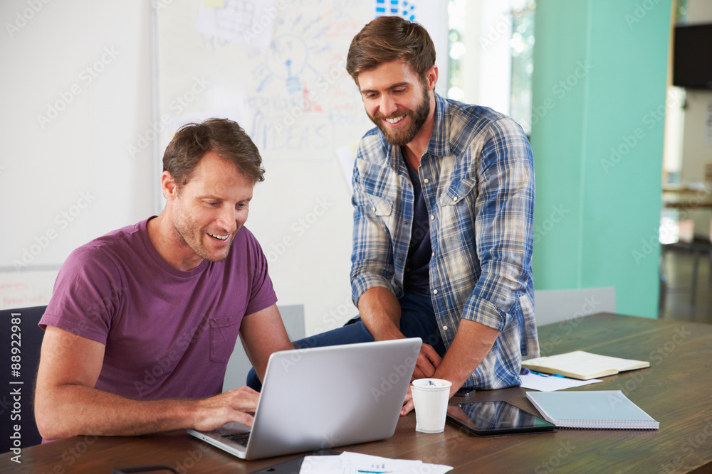 Two Businessmen Working On Laptop In Office Together Two Businessmen Working On Laptop In Office Together
