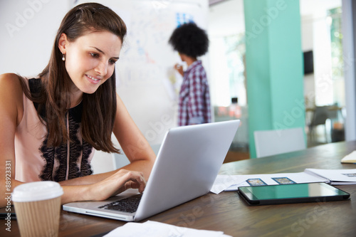 Two Businesswomen Working On Laptop In Office Together