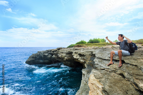 a man sitting at the edge of cliff express his feelings while lo