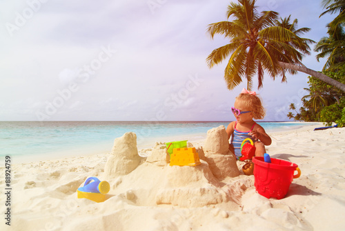 Fototapeta Naklejka Na Ścianę i Meble -  cute little girl playing with sand on tropical beach