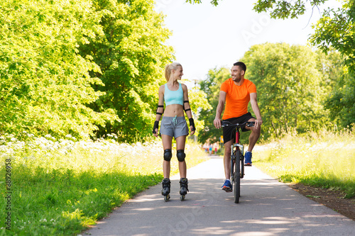 happy couple with rollerblades and bicycle riding