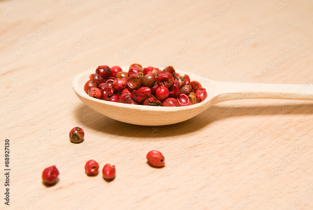spoon filled with of grains of pepper on a wooden surface spoon filled with of grains of pepper on a wooden surface