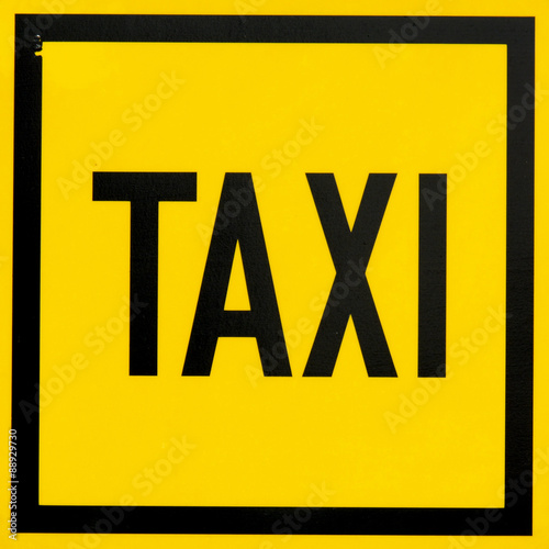 Beautiful yellow banner with black inscription taxi. Stock photo.