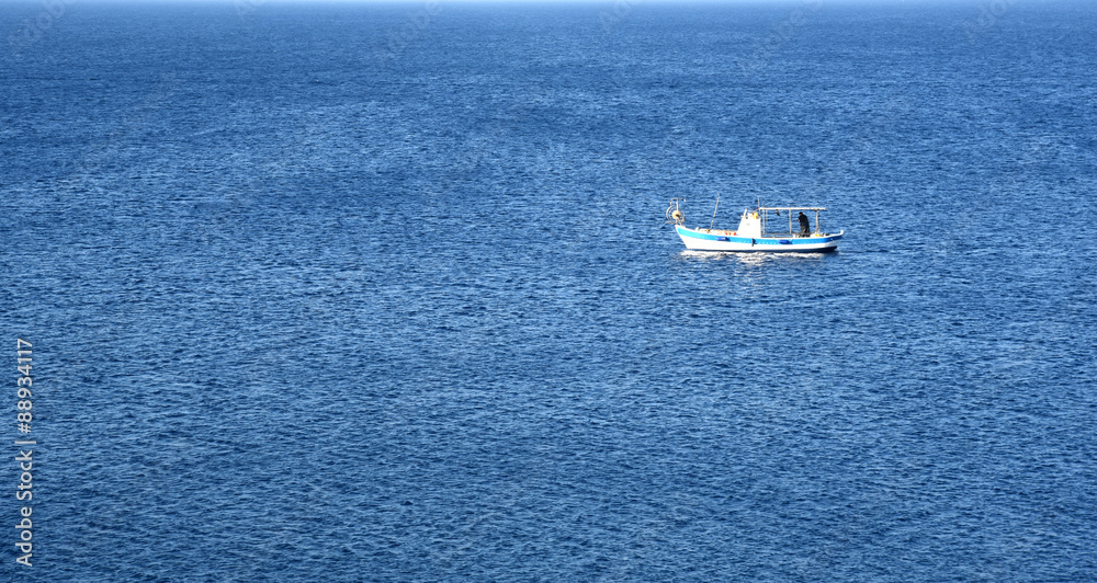 Lonely fishing Boat on a calm blue sea Lonely fishing Boat on a calm blue sea