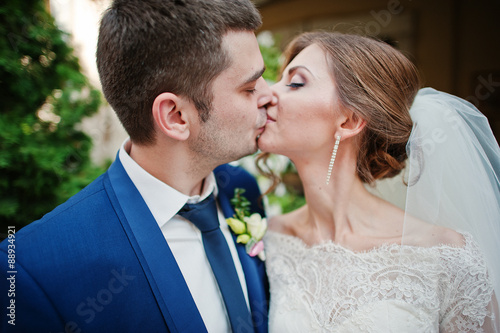 Close up portrait of kissing wedding couple