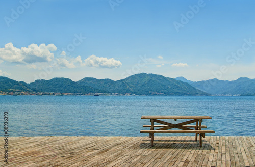 wooden table and benches for picnic by sea