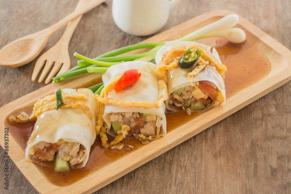 Spring rolls with vegetables and chicken on wooden plate Spring rolls with vegetables and chicken on wooden plate