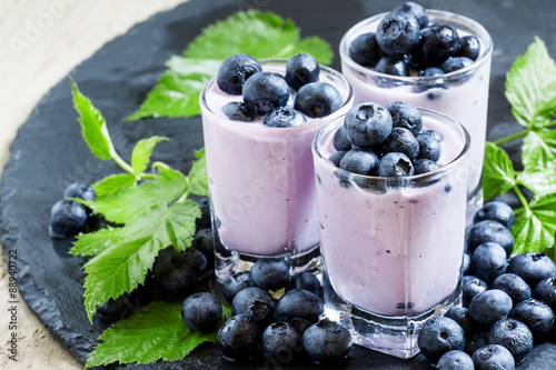 Lilac homemade yogurt with blueberries on a dark background, sel
