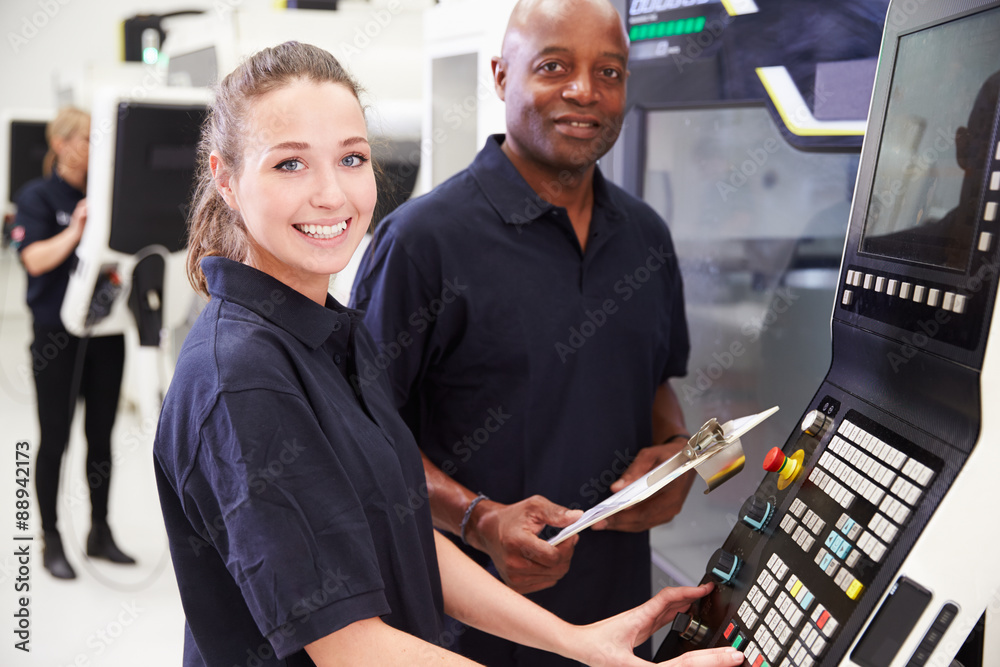 Fototapeta premium Portrait Of Apprentice Working With Engineer On CNC Machine