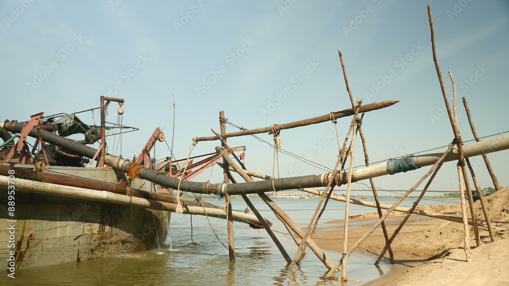 operation of pumping sand out of a dredging boat through a pipe hold between bamboo canes; dredging boat being tied to shore operation of pumping sand out of a dredging boat through a pipe hold between bamboo canes; dredging boat being tied to shore