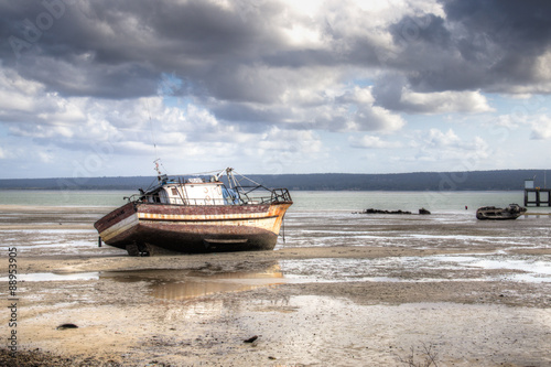 The view over the beach with the pier and old boats in the harbour of Inhambane in Mozambique  