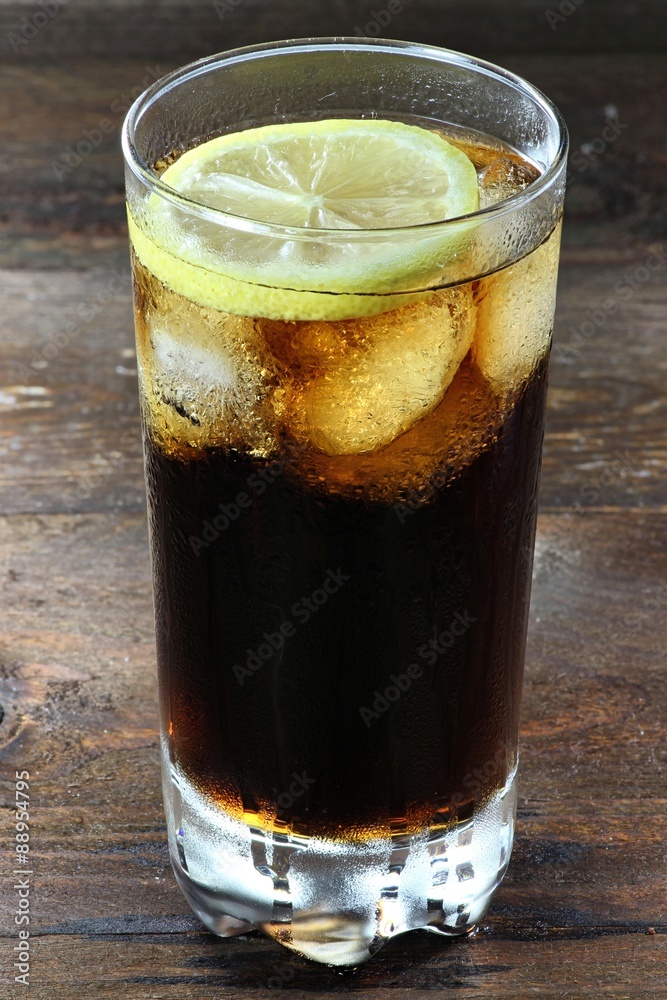 Cola mit Eiswürfeln und Zitronenscheibe auf Holztisch Cola mit Eiswürfeln und Zitronenscheibe auf Holztisch