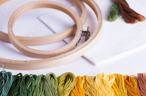 Embroidery yarns and hoops on fabric background