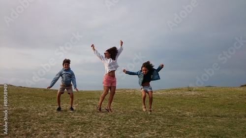 Madre e hijos saltando sobre la hierba