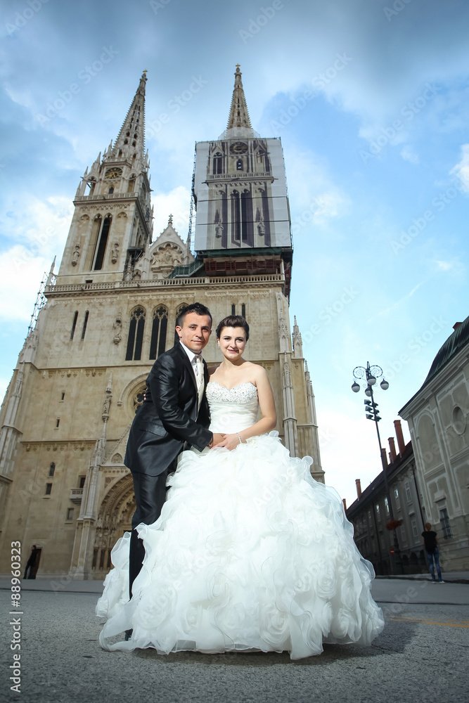 Obraz premium Newlyweds holding hands in city
