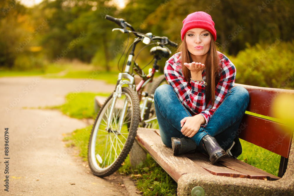 girl relaxing in autumnal park with bicycle.