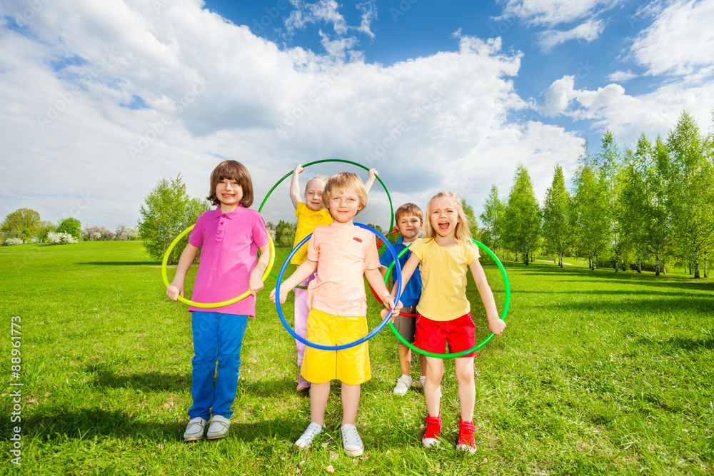 Kids hold hula hoops during exercising activity Kids hold hula hoops during exercising activity