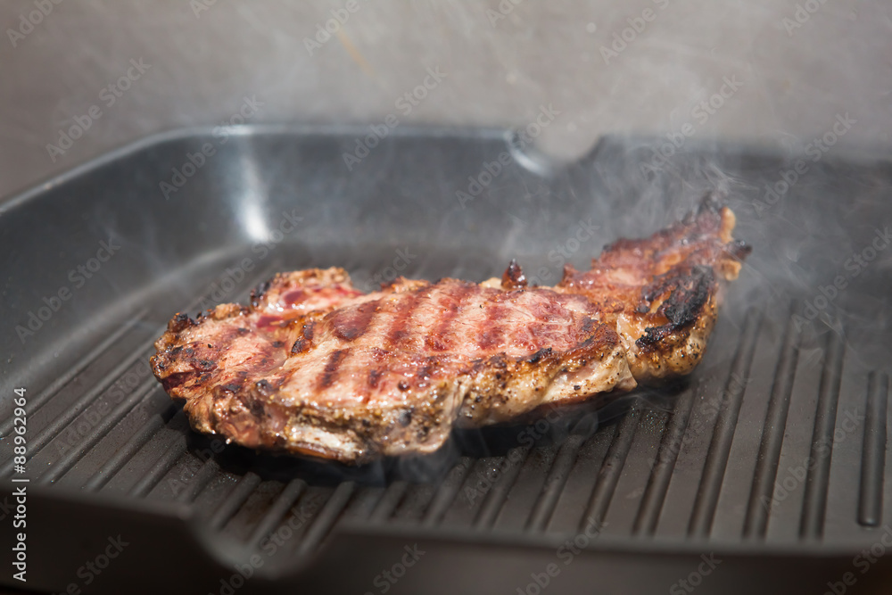 frying beef steak on a ribbed grill pan