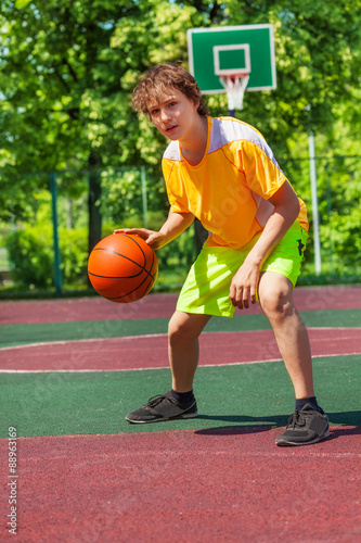 Boy playing with ball alone during basketball game