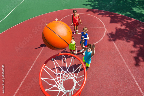 View of flying ball to basket from top, teens play