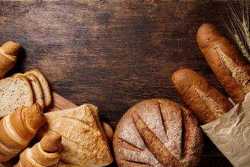 Papier peint photo Boulangerie Pains variés sur fond bois sombre  © valya82