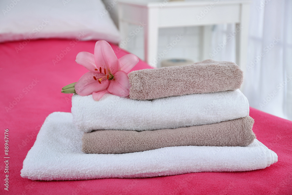 Freshly laundered fluffy towels in bedroom interior