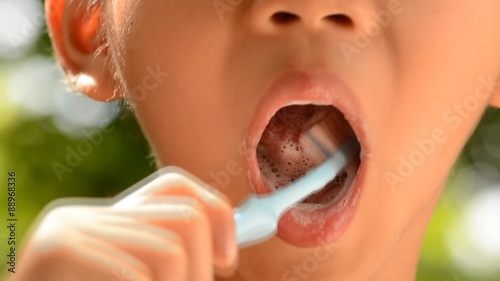 Close up boy brush tooth on green bokeh background