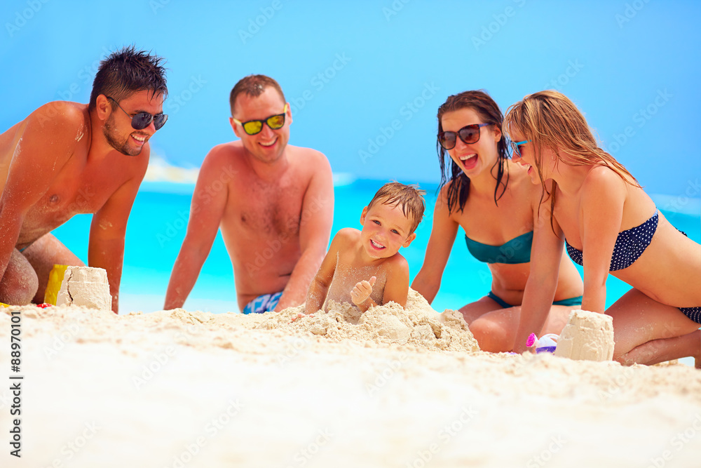 joyful friends having fun together on sandy beach, summer vacation