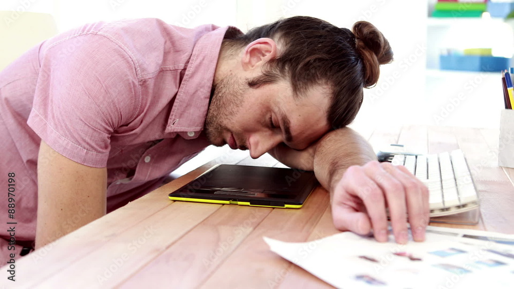 Overworked graphic designer sleeping on his desk Overworked graphic designer sleeping on his desk