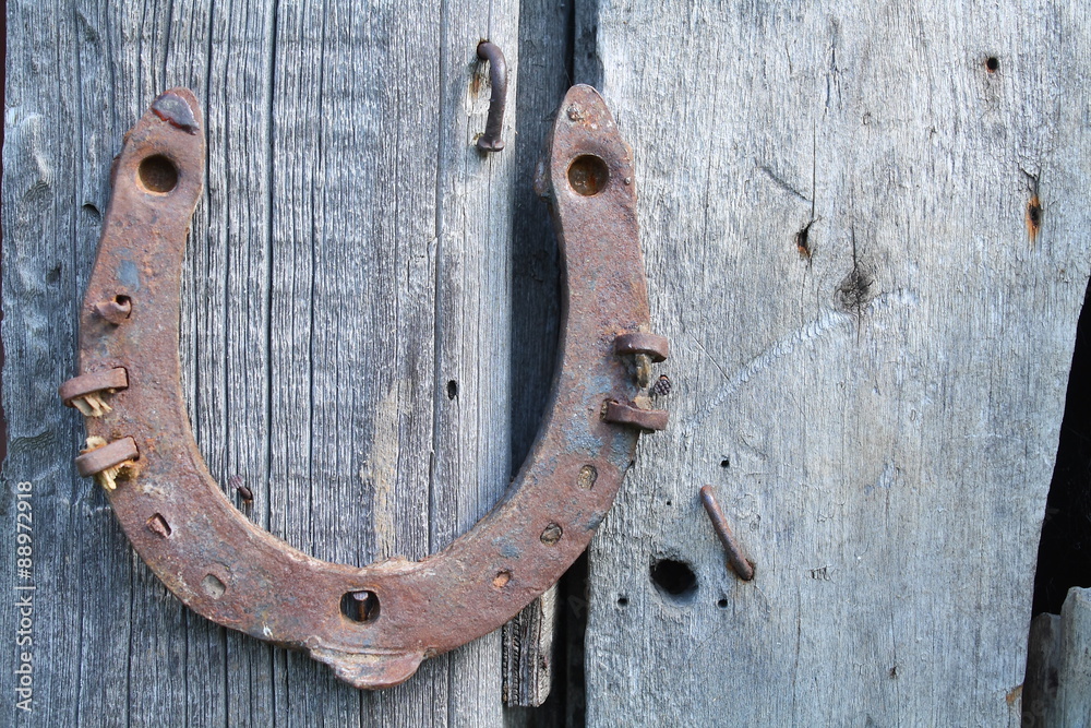 Forged horseshoe on the background of the old board Forged horseshoe on the background of the old board