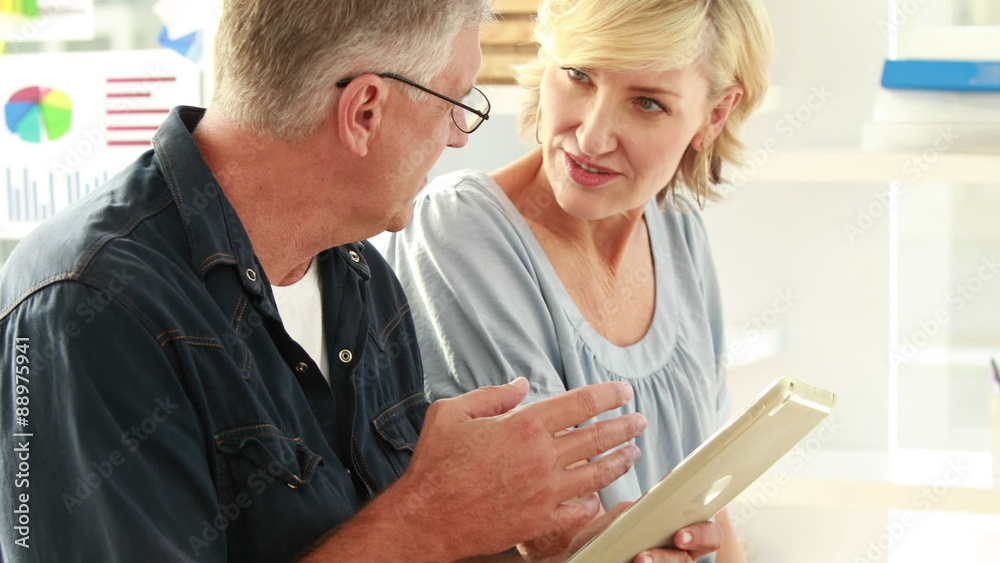 Casual business partners looking at tablet Casual business partners looking at tablet