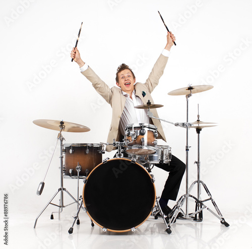 Fototapeta young man  on drums expresses joy